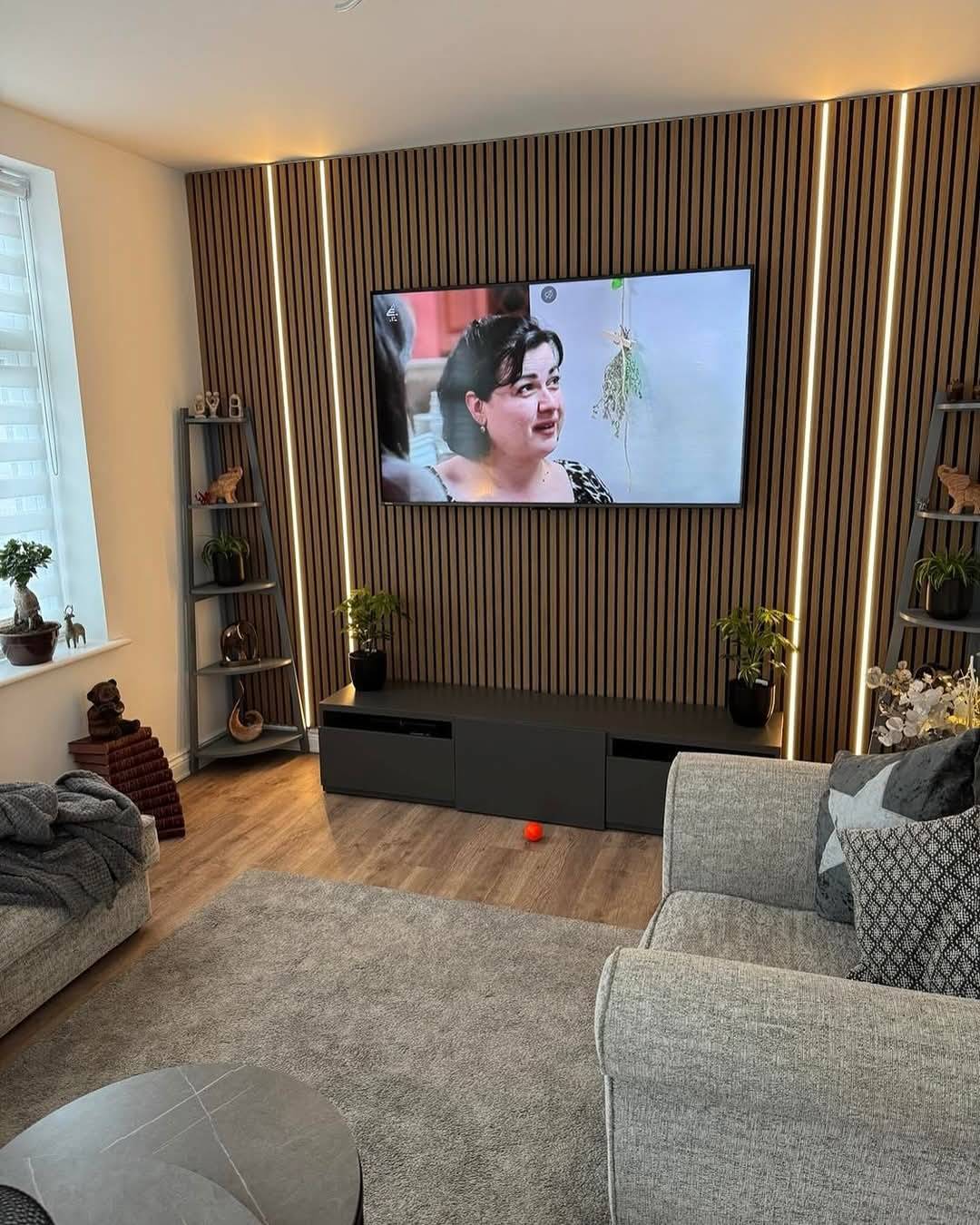 Brown wood grain slatted wall panel with white acoustic panels and integrated LED strip lighting from AWS.