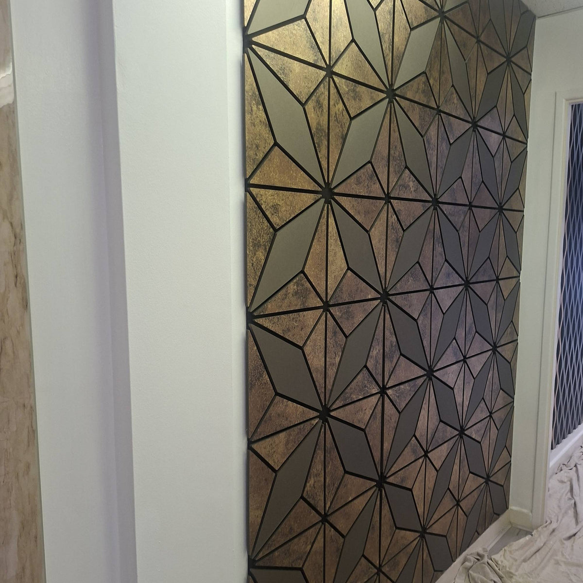 Distressed bronze geometric acoustic wall panel with irregular triangle design, 60x240cm, by The Panel Outlet Ireland.