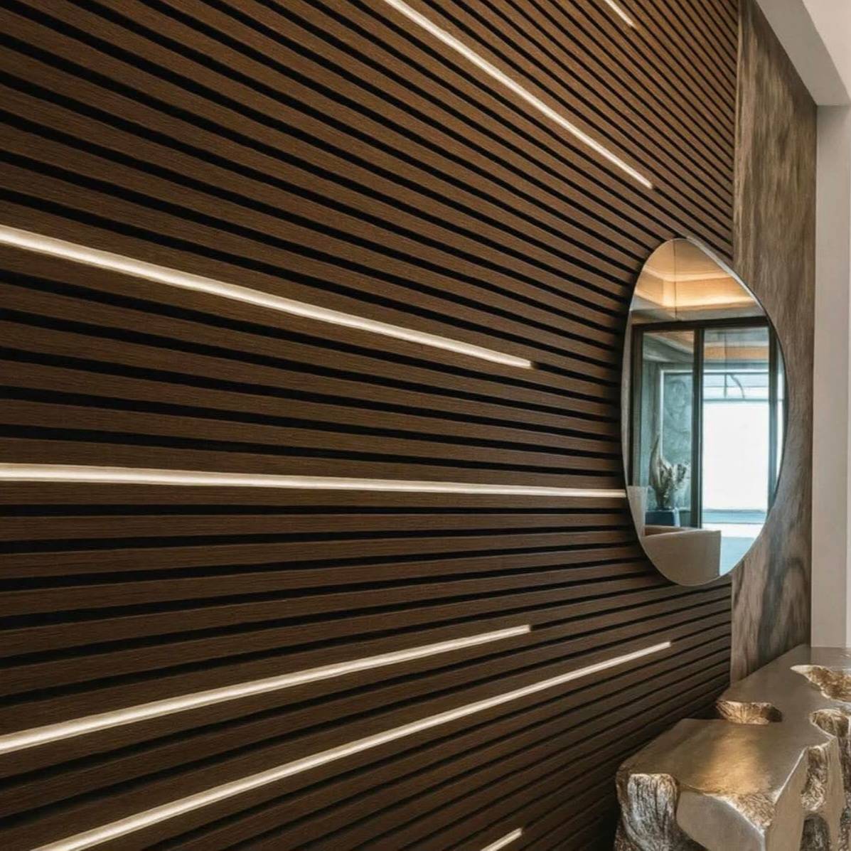 Dark brown wooden slatted wall panel with white LED strip lighting set, showcasing AWS Acoustic Wall Panel 240cm in a modern interior.
